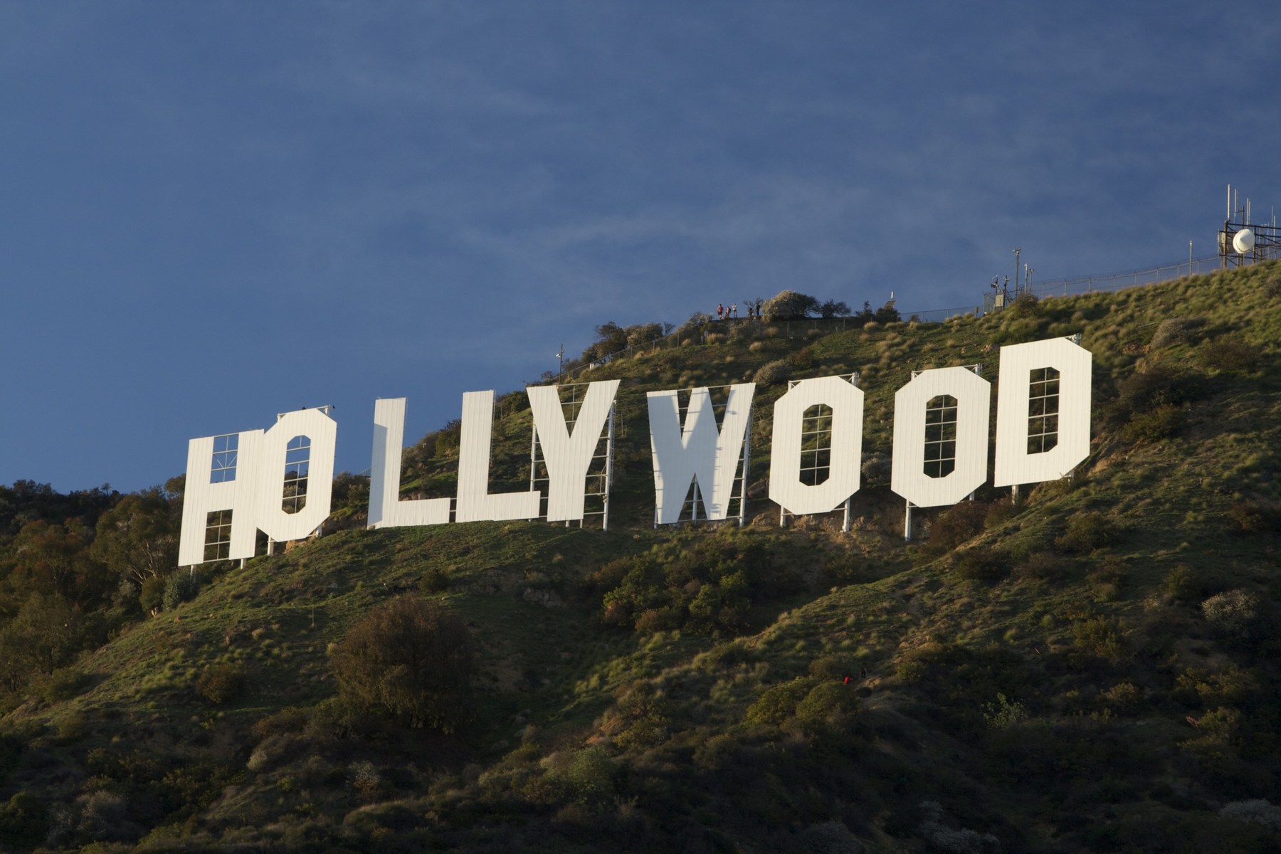 The white HOLLYWOOD letters on a green hillside beneath a blue sky.