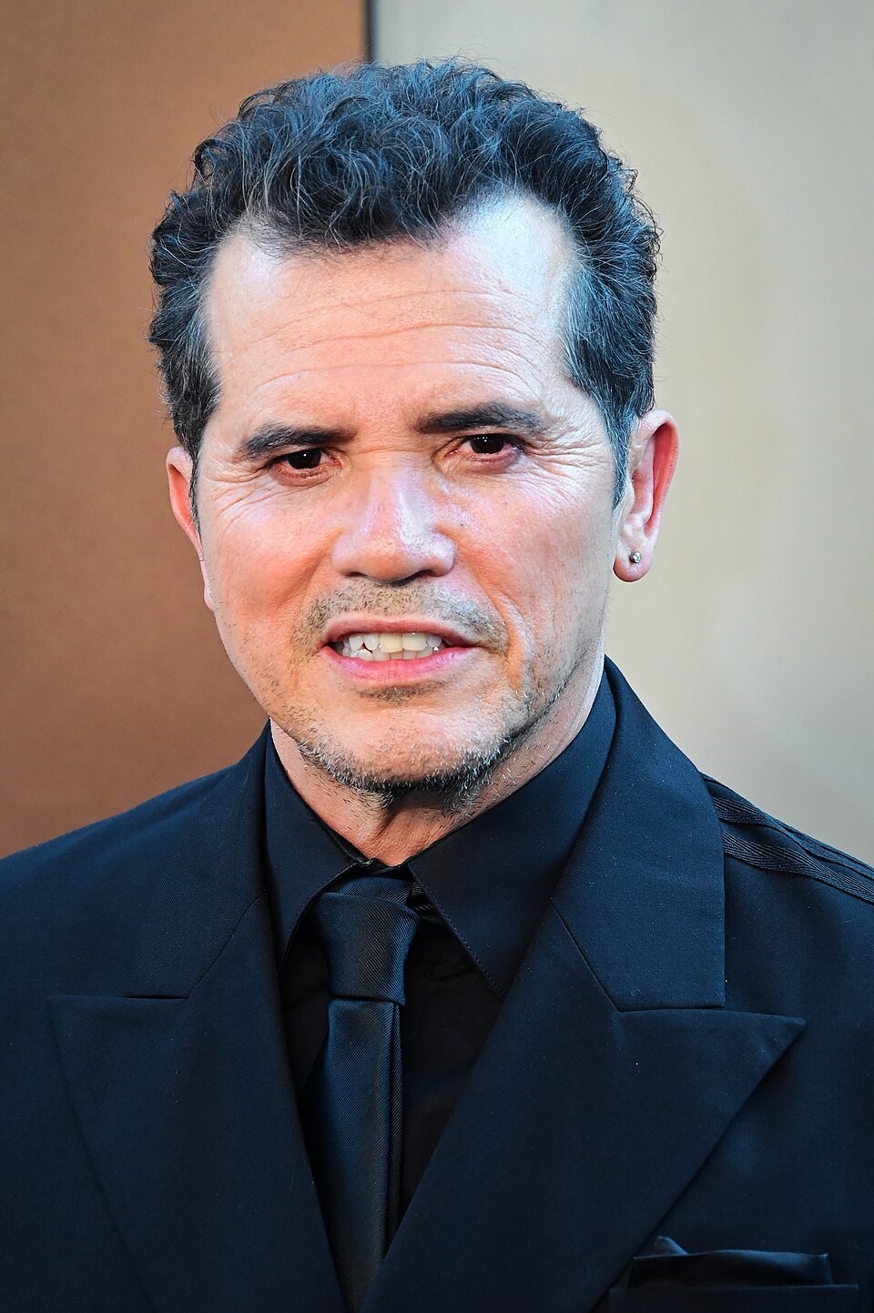 John Leguizamo wearing a dark suit and tie at the New York premiere of The Odyssey.